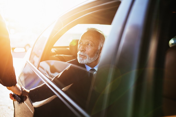 Senior business man sitting in his limousine. Business concept.