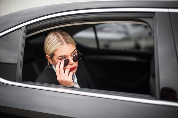 Business woman famous VIP celebrity public person in luxury car limousine. Female elegant fashion style. Money and finance concept